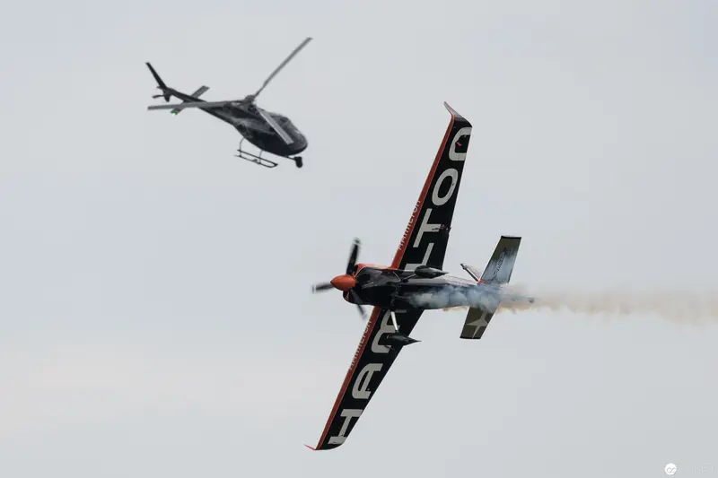 Red Bull Air Race Stunt Plane and Helicopter in Dynamic Aerial Maneuver