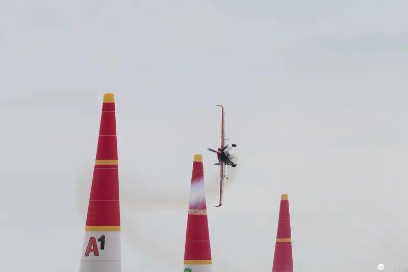 Red Bull Air Race Pilot Navigating Precision Markers Against Pale Sky