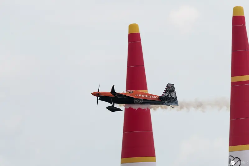 Hamilton-Branded Aerobatic Plane Navigating Red Pylons at Red Bull Air Race