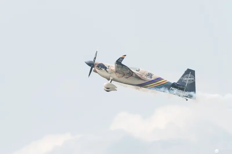 Red Bull Air Race Aerobatic Plane Executing Dynamic Maneuver in Cloudy Sky