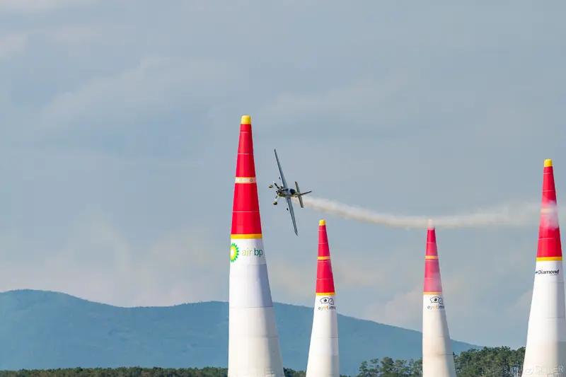 Red Bull Air Race Precision Flying Between Crimson Markers Over Mountain Landscape
