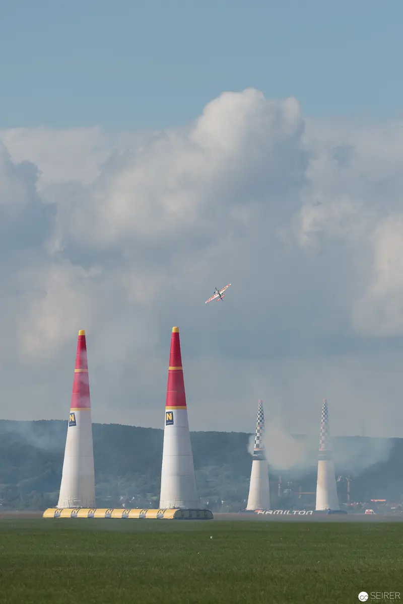 Red Bull Air Race Pylons with Racing Aircraft Above Verdant Landscape