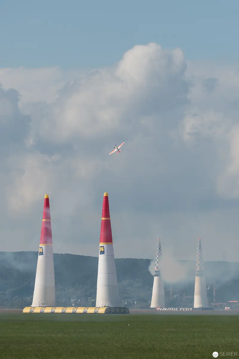 Red Bull Air Race Pylon Challenge with Aerial Precision over Verdant Landscape