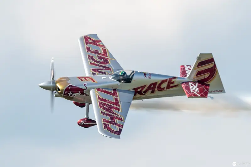 Red Bull Air Race Aerobatic Aircraft in Dynamic Silver and Red Flight Maneuver
