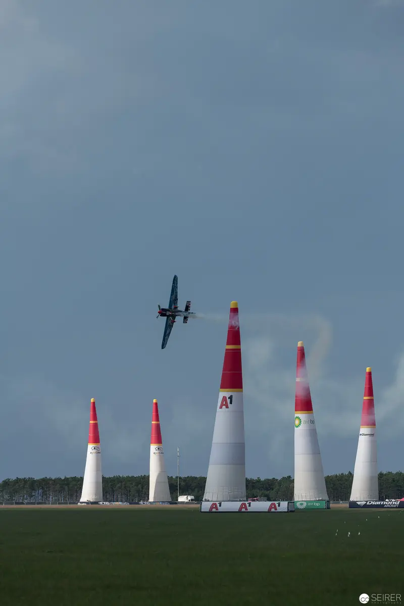 Red Bull Air Race Plane Navigating Tall Red and White Pylons