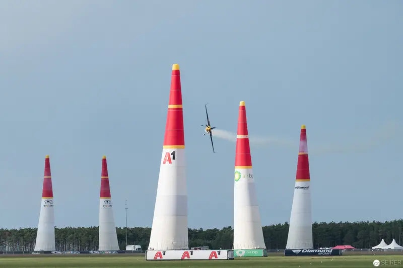 Red Bull Air Race Pylons with Racing Aircraft Above Landscape Terrain