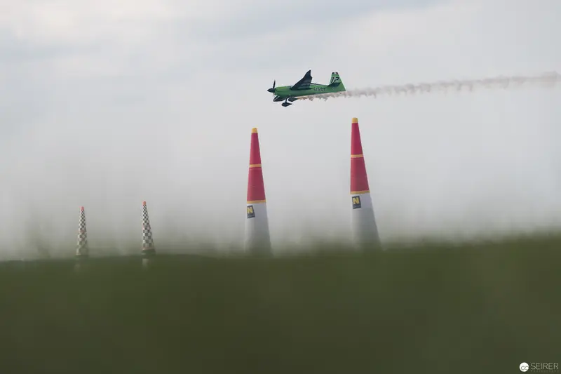 Red Bull Air Race: Precision Aircraft Navigating Crimson Pylons Through Misty Terrain