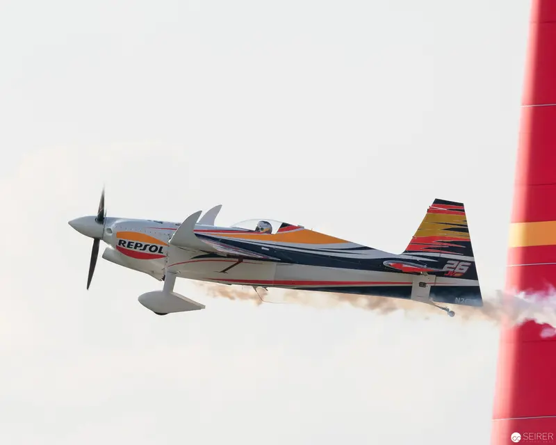 Repsol-Sponsored Aerobatic Aircraft Executing Precision Maneuver at Air Race Event