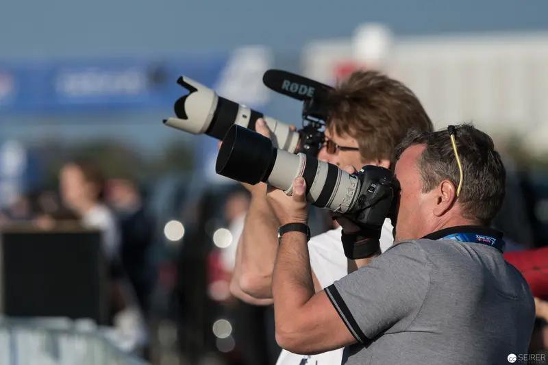 Photographer with Telephoto Lens Capturing Red Bull Air Race Event