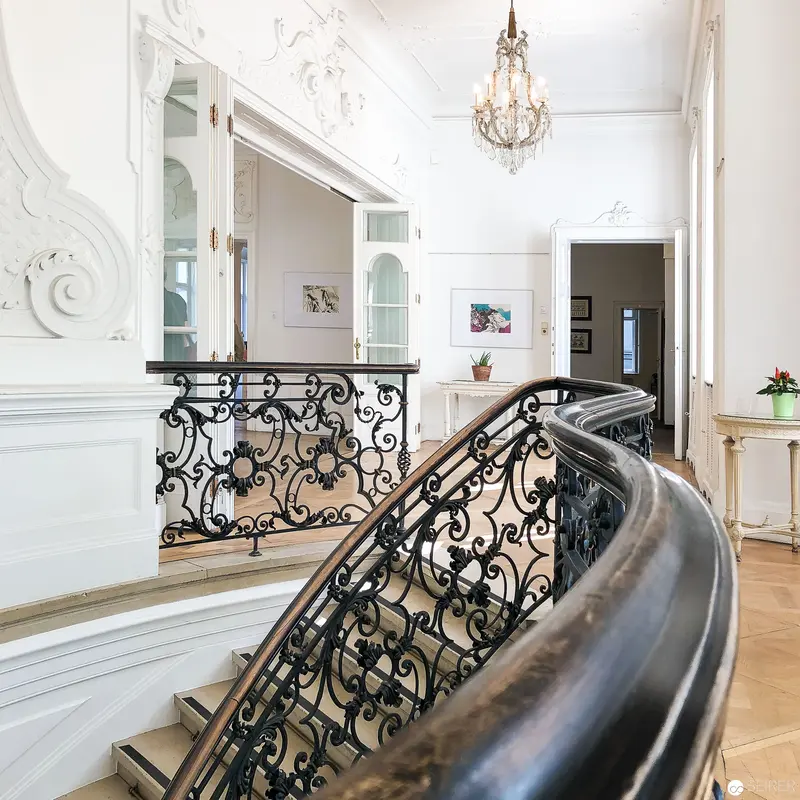 Ornate Staircase with Intricate Wrought Iron Railing in Elegant Interior