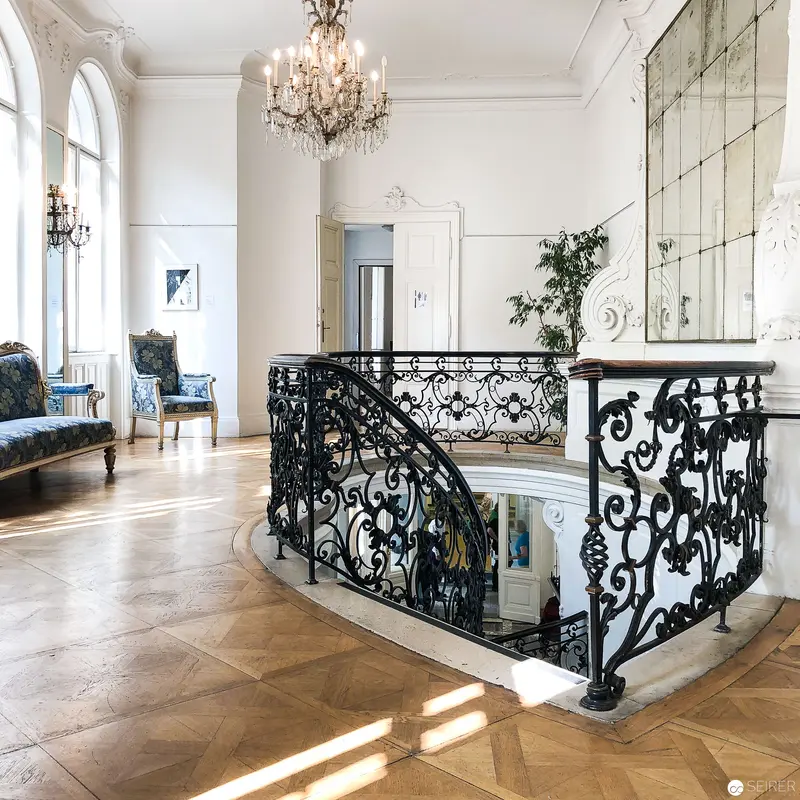Elegant Viennese Interior with Ornate Wrought-Iron Staircase and Crystal Chandelier