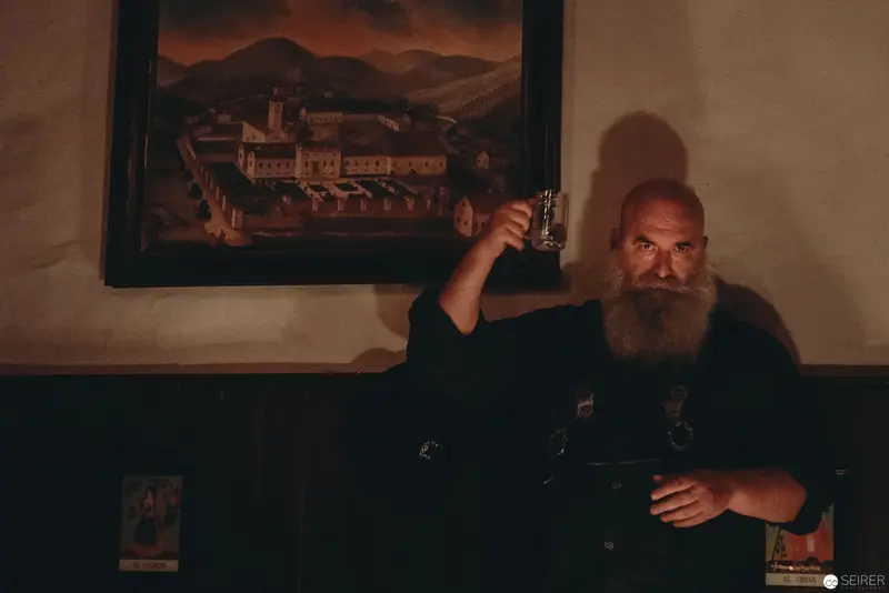 Nesterval's "Das Dorf": Bearded Performer in Dimly Lit Contemplative Scene