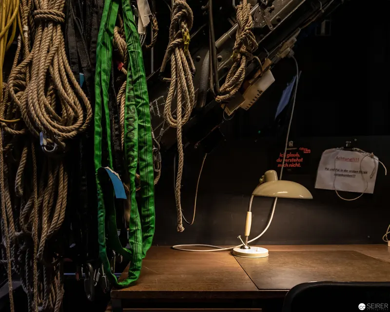 Illuminated Nautical Workspace with Vintage Desk Lamp and Maritime Ropes