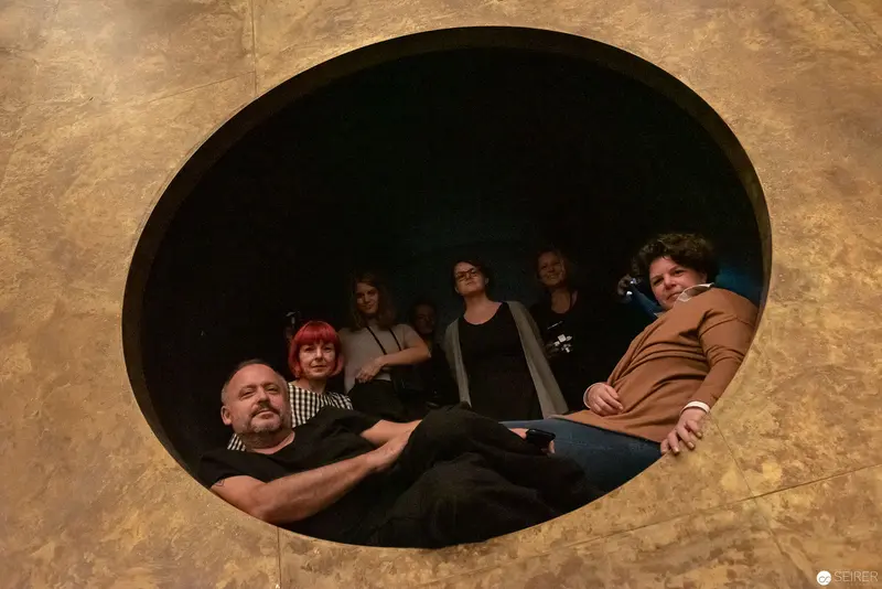 Group Gathered in Circular Aperture, Seated in Contemplative Poses