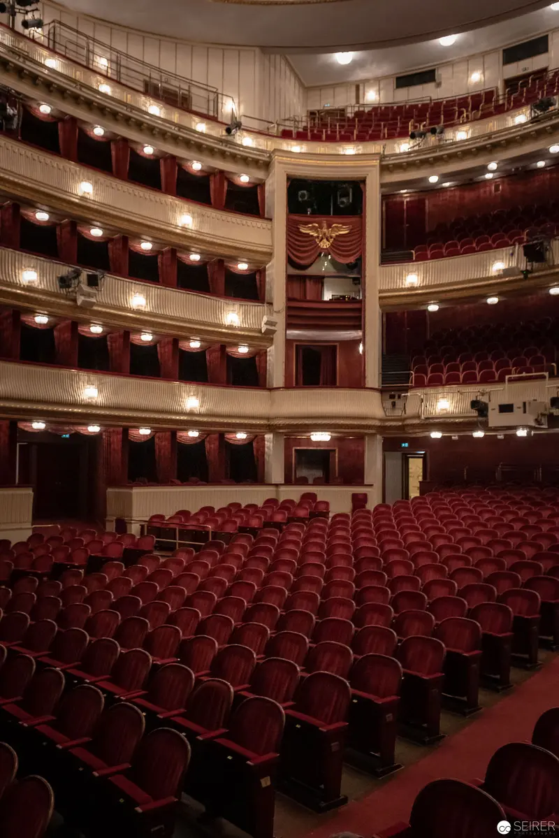 Ornate Classical Theatre Interior with Red Upholstered Seating and Multiple Balconies