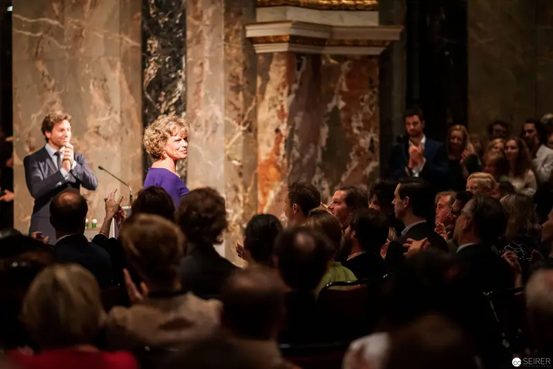 Lecture at Ornate Historical Venue with Distinguished Speaker in Purple