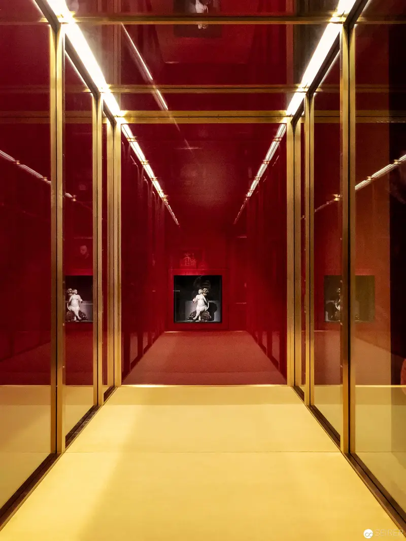 Red Corridor Installation with Reflective Surfaces and Staged Figure
