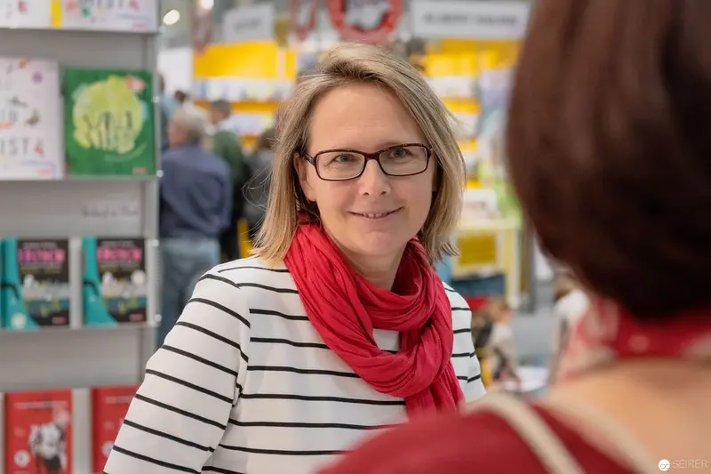 Janett Cernohuby at Buch Wien Book Fair in Striped Shirt and Red Scarf