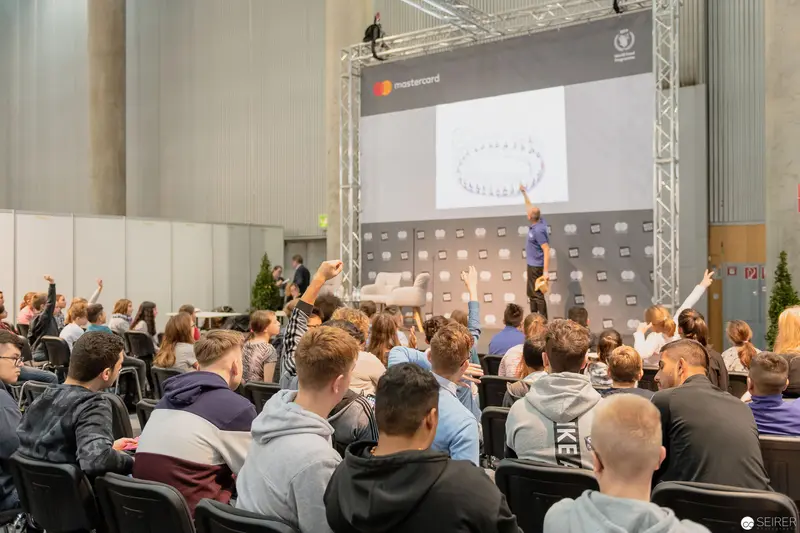 Mastercard Conference Audience Raises Hands During Interactive Presentation Session