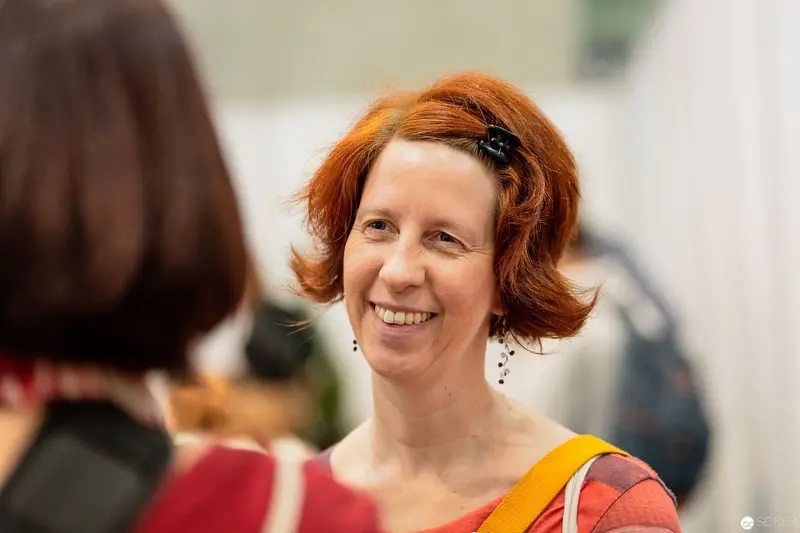 Janett Cernohuby Smiling at Buch Wien Event in Warm-Toned Conversation