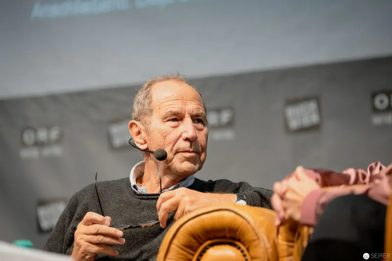 Veteran Speaker Discussing with Microphone at Media Event