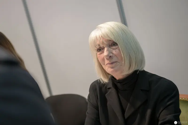 Senior Woman in Black Blazer During Contemplative Office Interaction