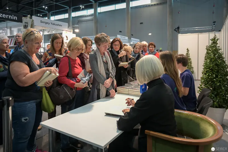 Book Signing Event with Crowd Gathered Around Information Table