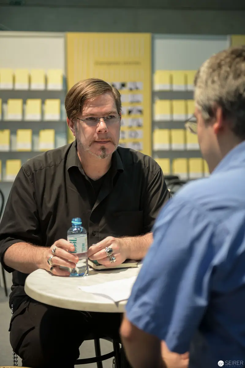 Workplace Meeting: Two Colleagues Discussing Project at Round Table