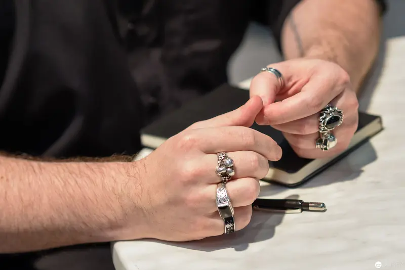Silver Rings and Contemplative Hands on Writing Surface