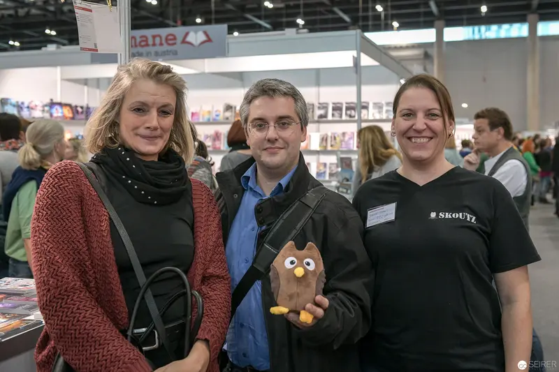 Book Fair Attendees with Plush Owl at Publishing Event