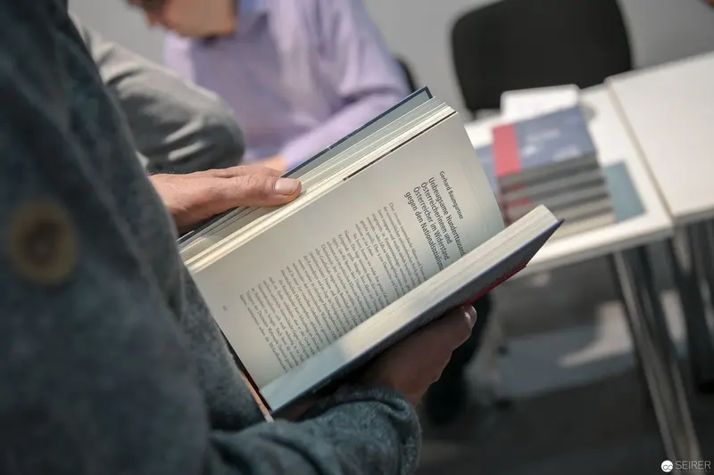Intimate Reading Moment: Hands Holding Open Book in Contemplative Setting