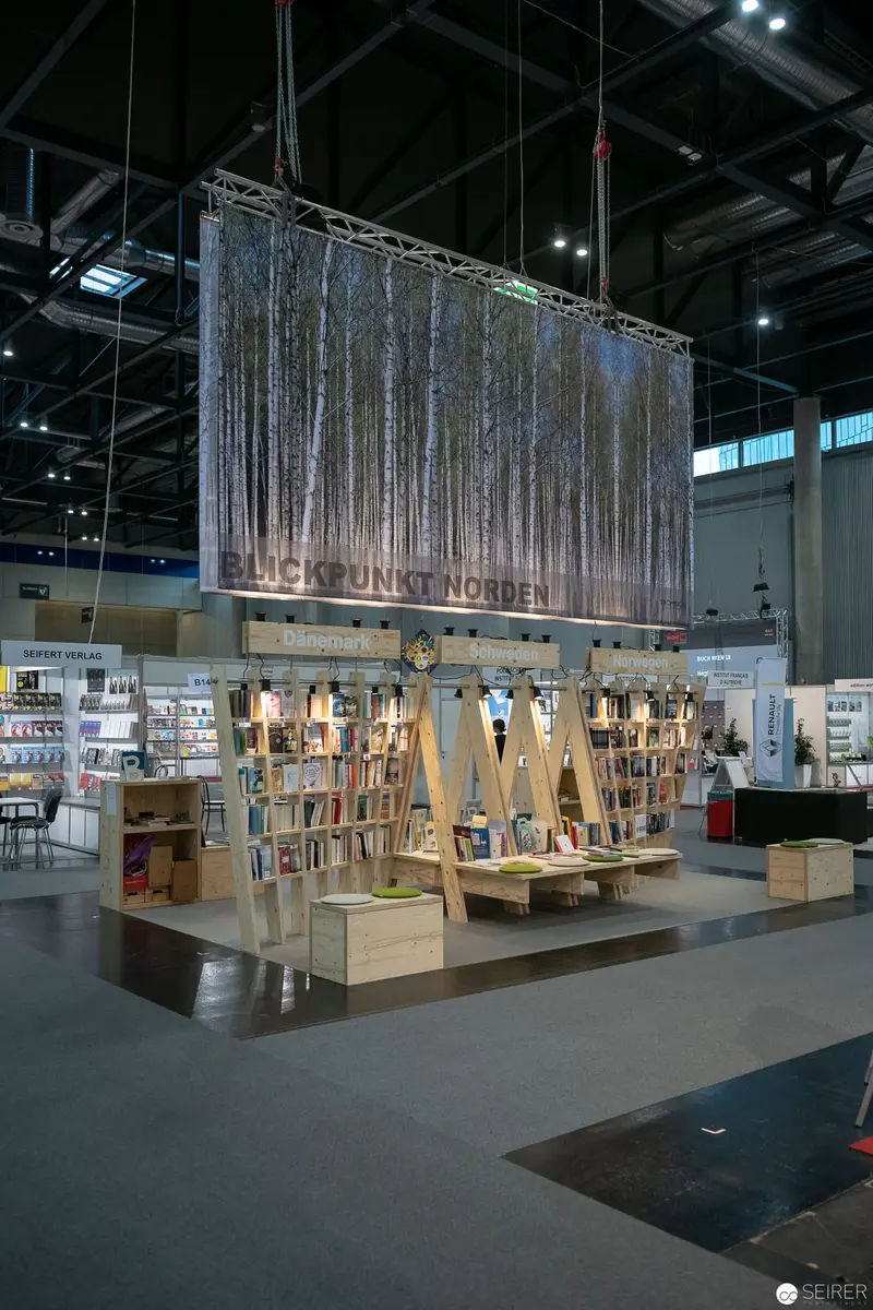 Book Exhibition Display with Woodland Backdrop in Contemporary Museum Space