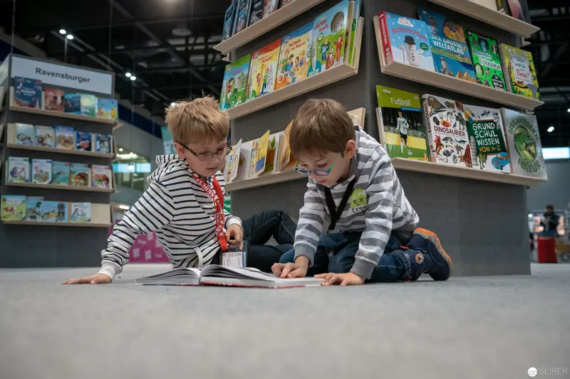Young Readers Exploring Children's Books at Ravensburger Display