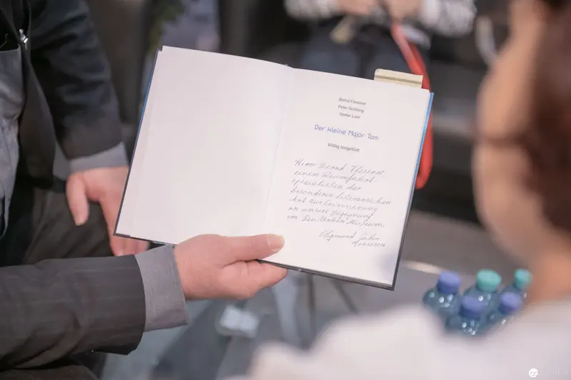 Book Presentation Moment: Handwritten Page Revealed at Literary Event