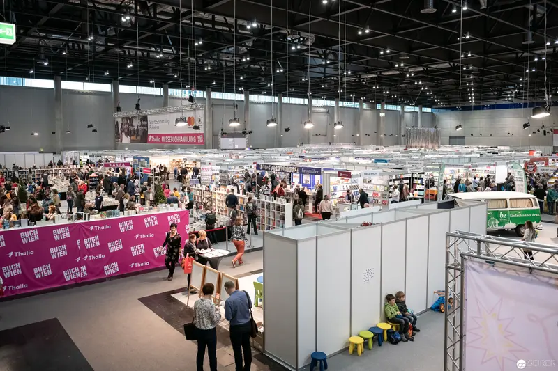 Buch Wien Literary Fair: Expansive Exhibition Hall with Diverse Book Displays and Attendees