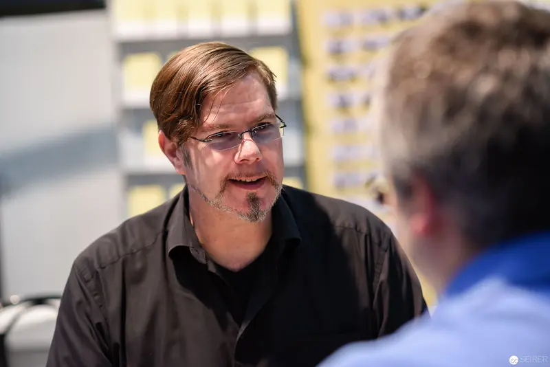 Professional Discussion in Office Setting with Man in Black Shirt