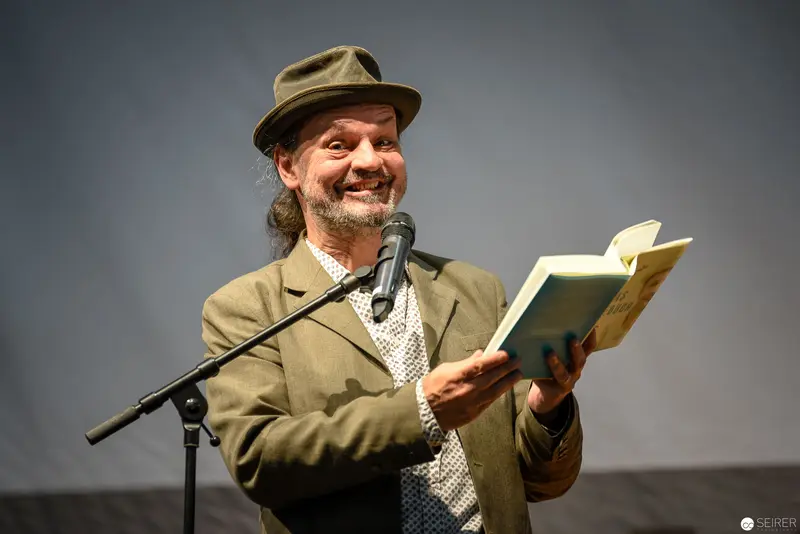 Bearded Storyteller Performing Literary Reading at Microphone