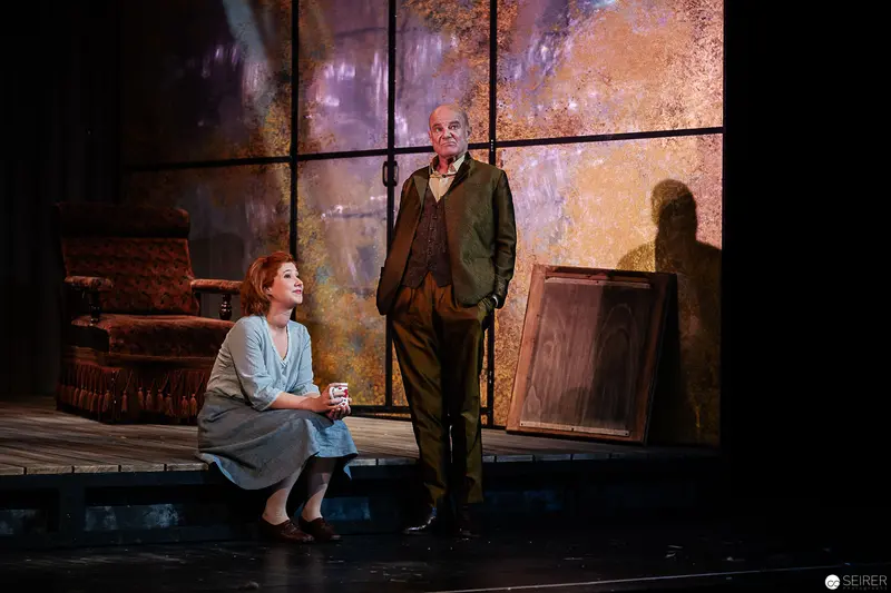 Wolfgang Hübsch and Julia Stemberger on Dramatic Stage Set with Textured Backdrop