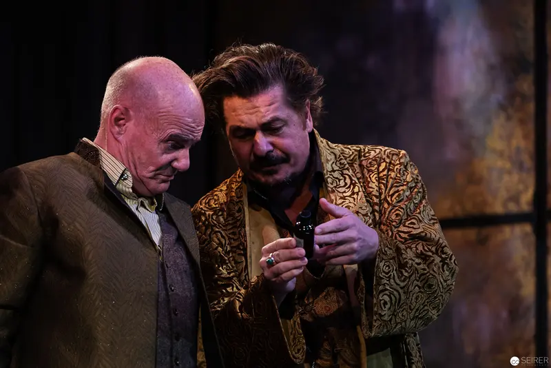 Zenobius and Tophan in Dramatic Theatrical Interaction Under Moody Stage Lighting