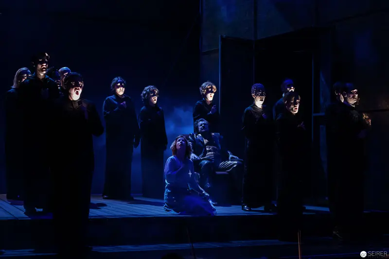Lakrimosa's Magical Realm: Dark Theatrical Tableau with Performers in Blue Light