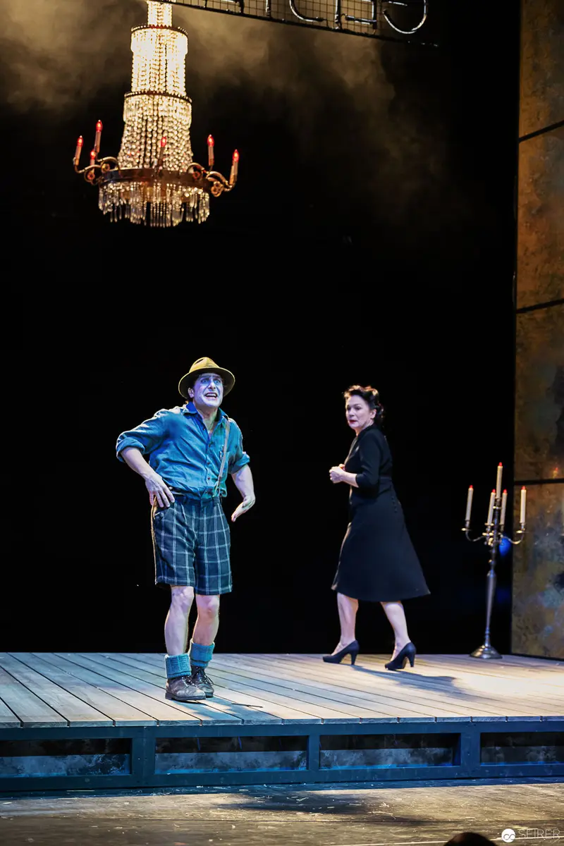 Lakrimosa and Bustorius on Staged Platform beneath Ornate Chandelier