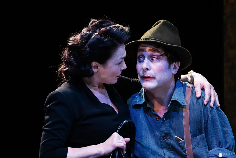 Intimate Theatrical Moment Between Two Performers in Dark Stage Lighting