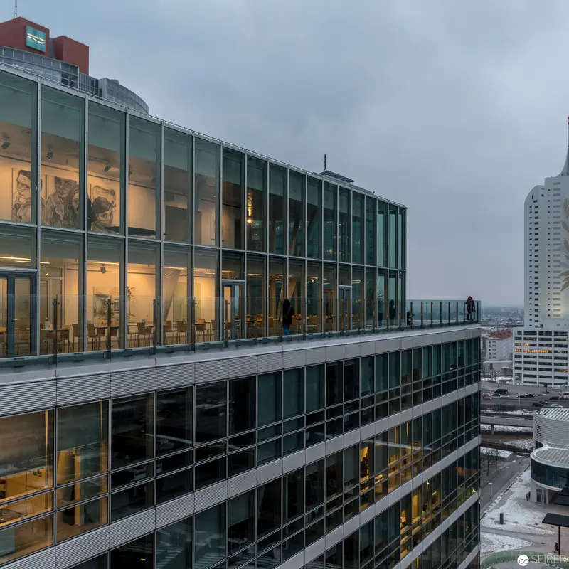 Modern Glass Office Complex with Illuminated Interior in Urban Twilight Setting