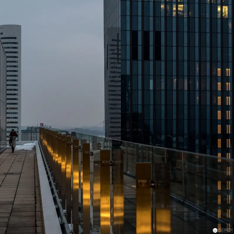 Urban Twilight: Glass Barrier and Illuminated Architecture at Dusk