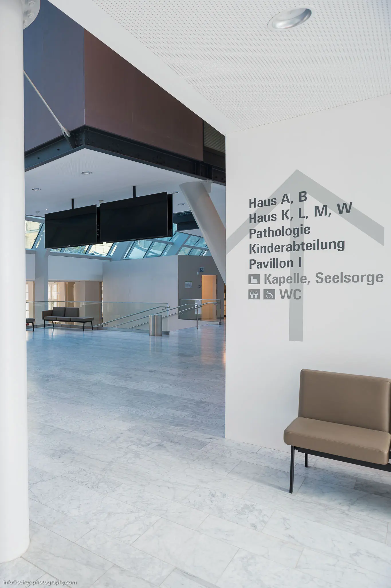 Modern Hospital Corridor Interior with Wayfinding Signage at Medical Facility