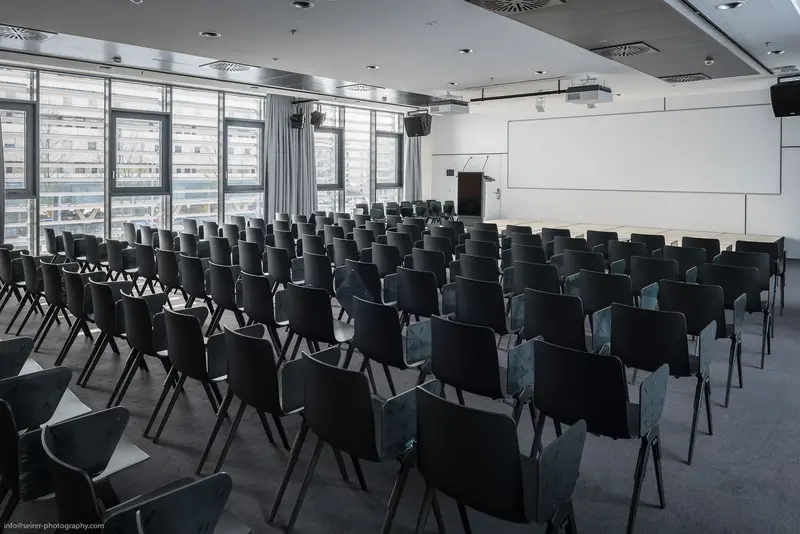 Empty Conference Room with Black Chairs in Modern Glass-Walled Lecture Hall