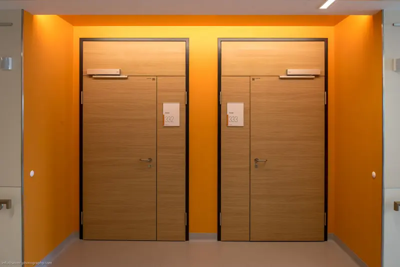 Symmetrical Wooden Doors in Vibrant Orange Architectural Corridor