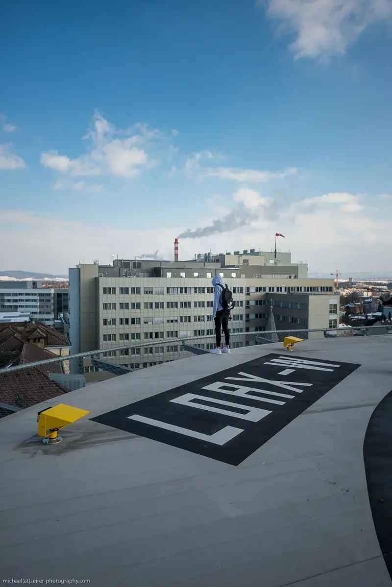 Urban Rooftop Landscape with Large Corporate Signage Against Blue Sky