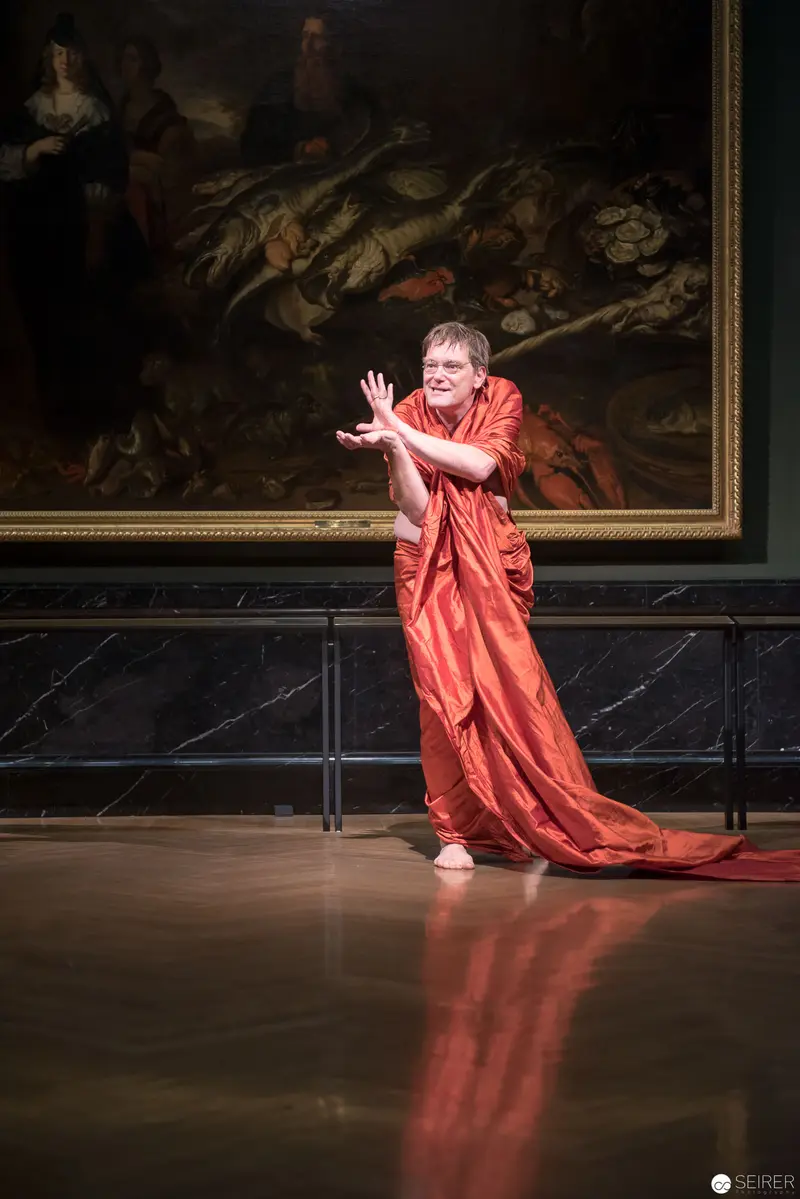 Performer in Vibrant Red Robe at Kunsthistorisches Museum Wien during Ganymed Performance