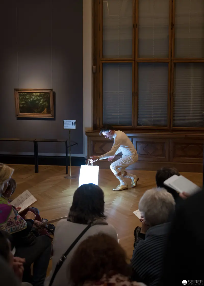 Performance of Ganymed at Kunsthistorisches Museum Wien, Performer in White Illuminated by Gallery Light